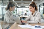Digitaler Nomade arbeitet mit Laptop und Visa-Dokumenten in einem modernen deutschen Coworking Space.