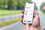 Smartphone mit digitalem Führerschein und deutschem Verkehrsschild im Hintergrund