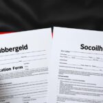 Vergleich zwischen Bürgergeld- und Sozialhilfe-Anträgen auf einer Deutschlandflagge liegend.